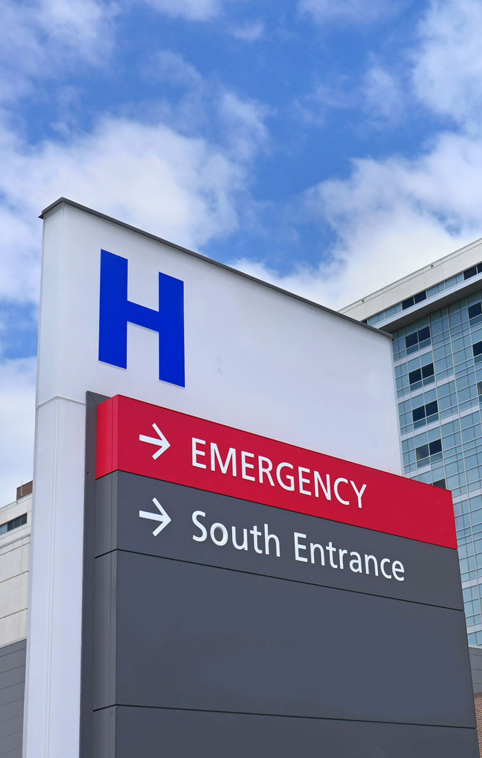 A hospital sign pointing to the emergency entrance